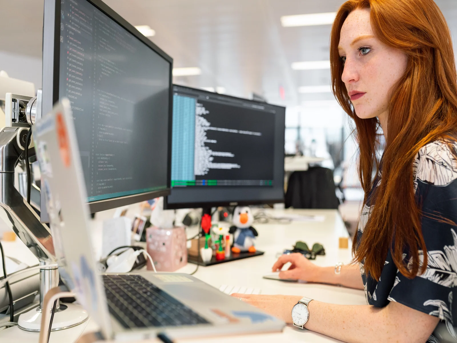 A GSB Solutions billing specialist working at a dual-monitor workstation, actively reviewing a claims queue and payer correspondence